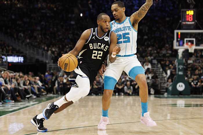 Milwaukee Bucks forward Khris Middleton (22) drives for the basket around Charlotte Hornets forward P.J. Washington (25)